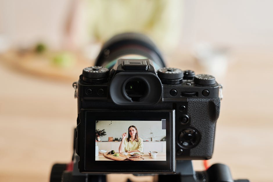 pexels-photo-4152611-4152611 Caucasian woman vlogging at home with camera in a kitchen setting, captured indoors.